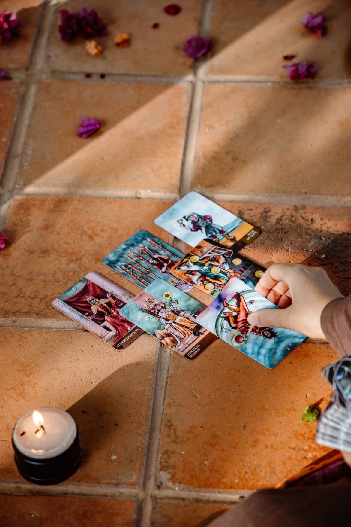 tarot cards laid out beside a lit candle during a psychic reading